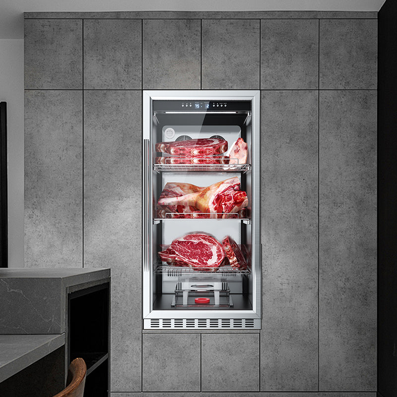 Single dry aging cabinet built into a gray tiled wall niche, glass door open view showing three shelves of raw meat cuts.