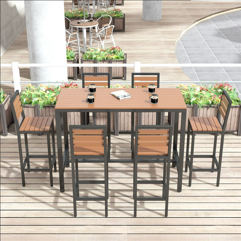 Overhead view of outdoor bar table set with 6 stools, mugs, and a magazine on top