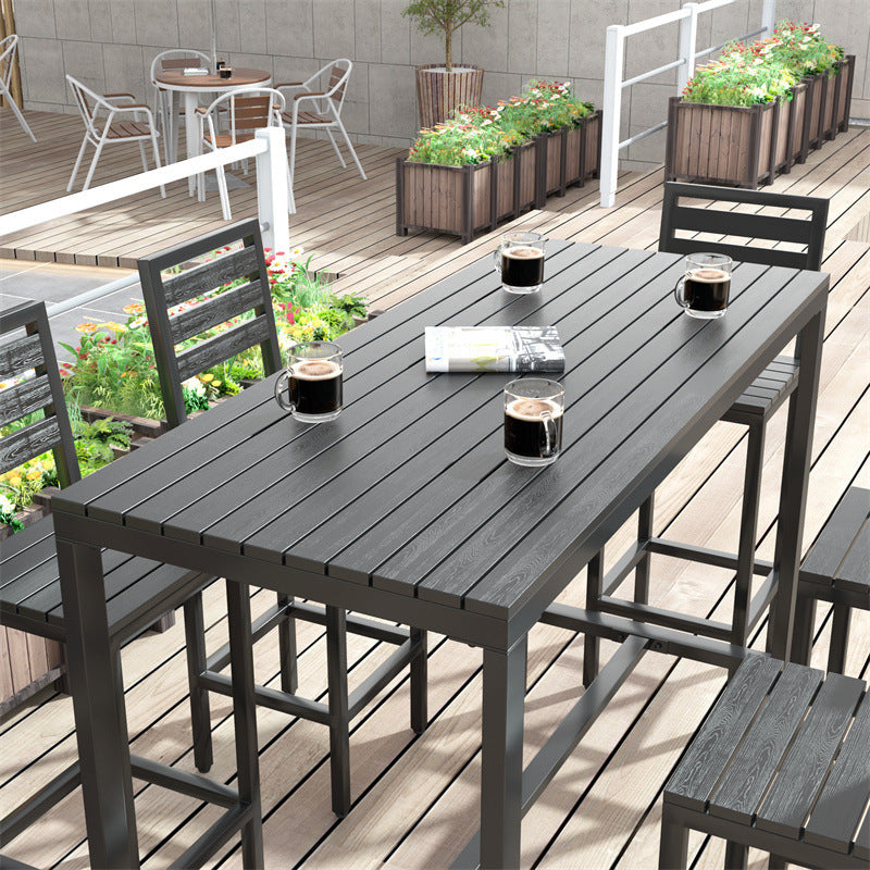 Dark wood-look bar table with bar stools and coffee mugs on an outdoor deck